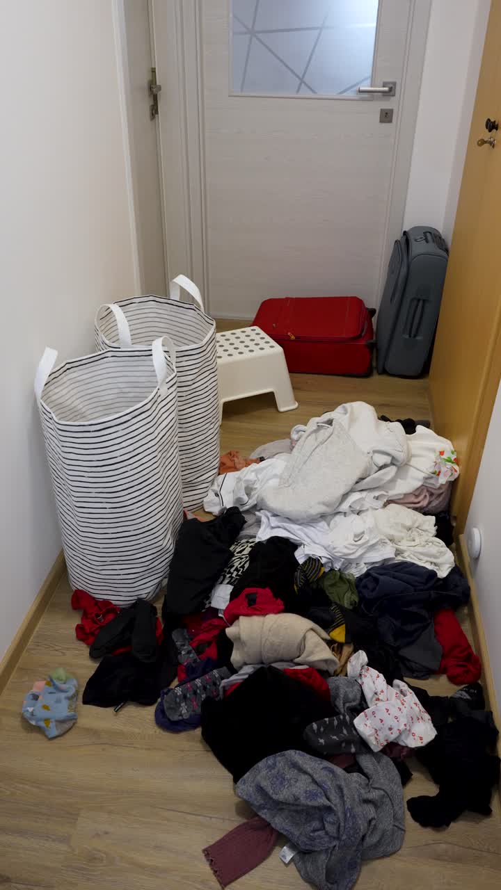 Large Pile of Dirty Laundry on Floor in Hallway at Home, Cluttered Floor, Vertical Shot