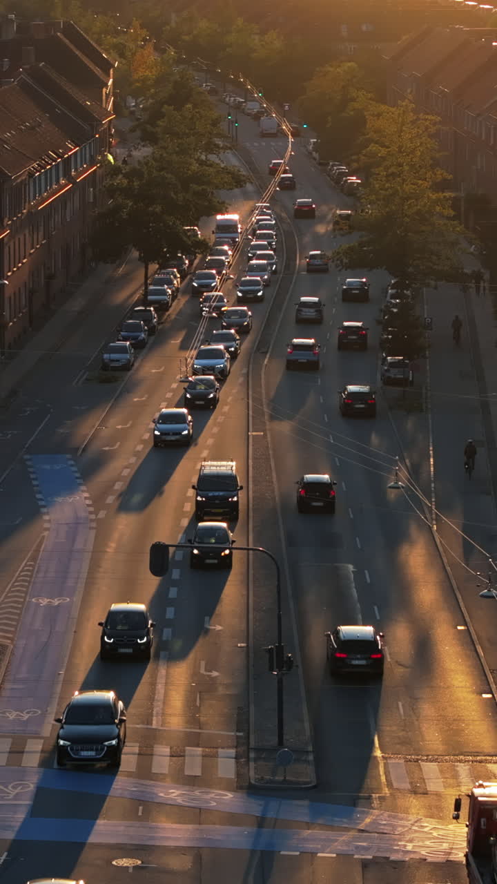 Aerial drone view of cars moving on the streets of Vesterbro district in Copenhagen, Denmark at sunset. Vertical
