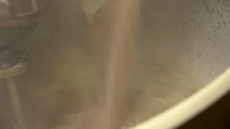 Pouring the milled grain into the mash tun in the process of brewing beer