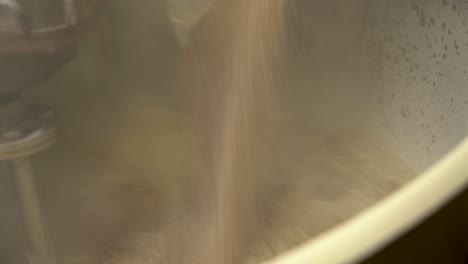 Pouring-the-milled-grain-into-the-mash-tun-in-the-process-of-brewing-beer