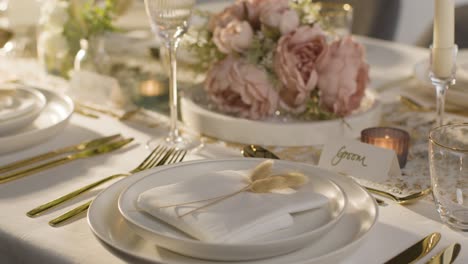 close up of table set for meal at wedding reception with place card for groom