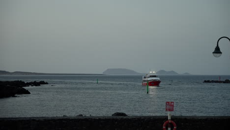 ferry enters the port in lanzarote at dusk