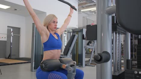 mujer realizando un ejercicio de lat pulldown en un gimnasio