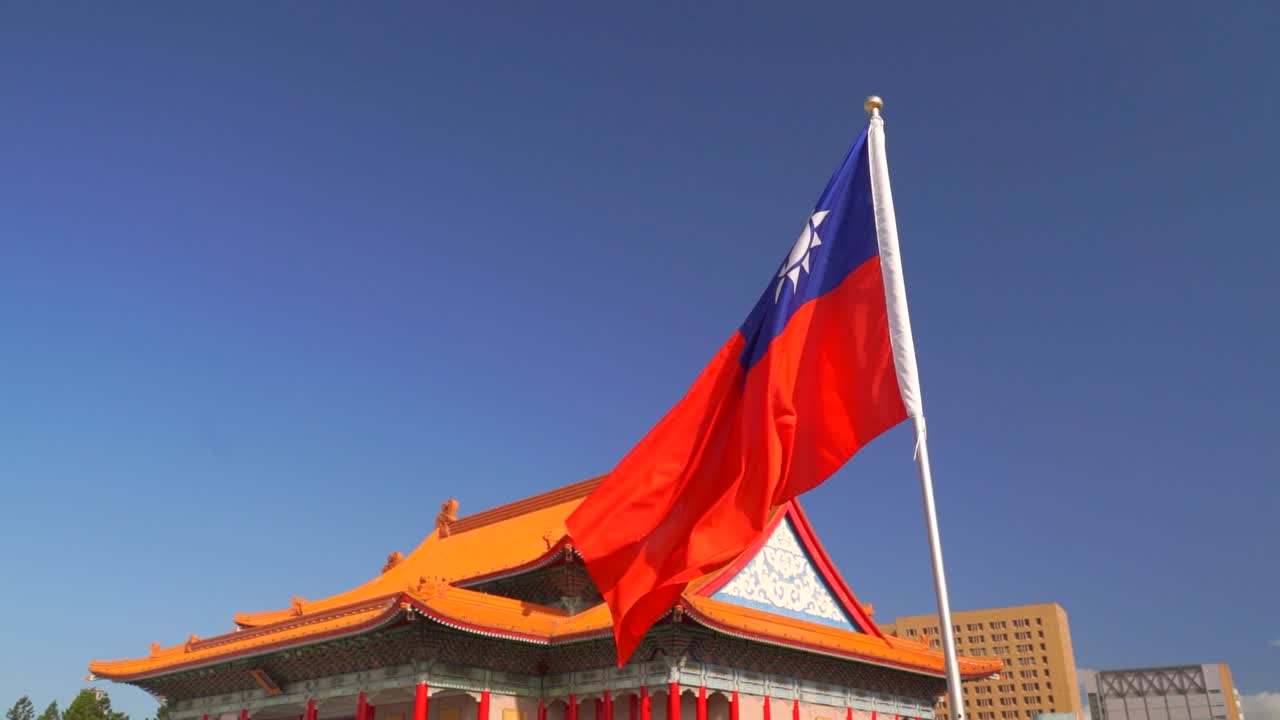 Bandiera nazionale di Taiwan che sventola contro un cielo blu e un edificio dalla tipica architettura