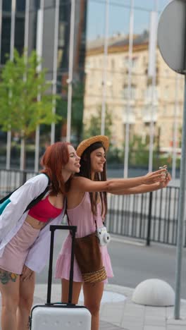 two women taking a selfie while traveling in the city