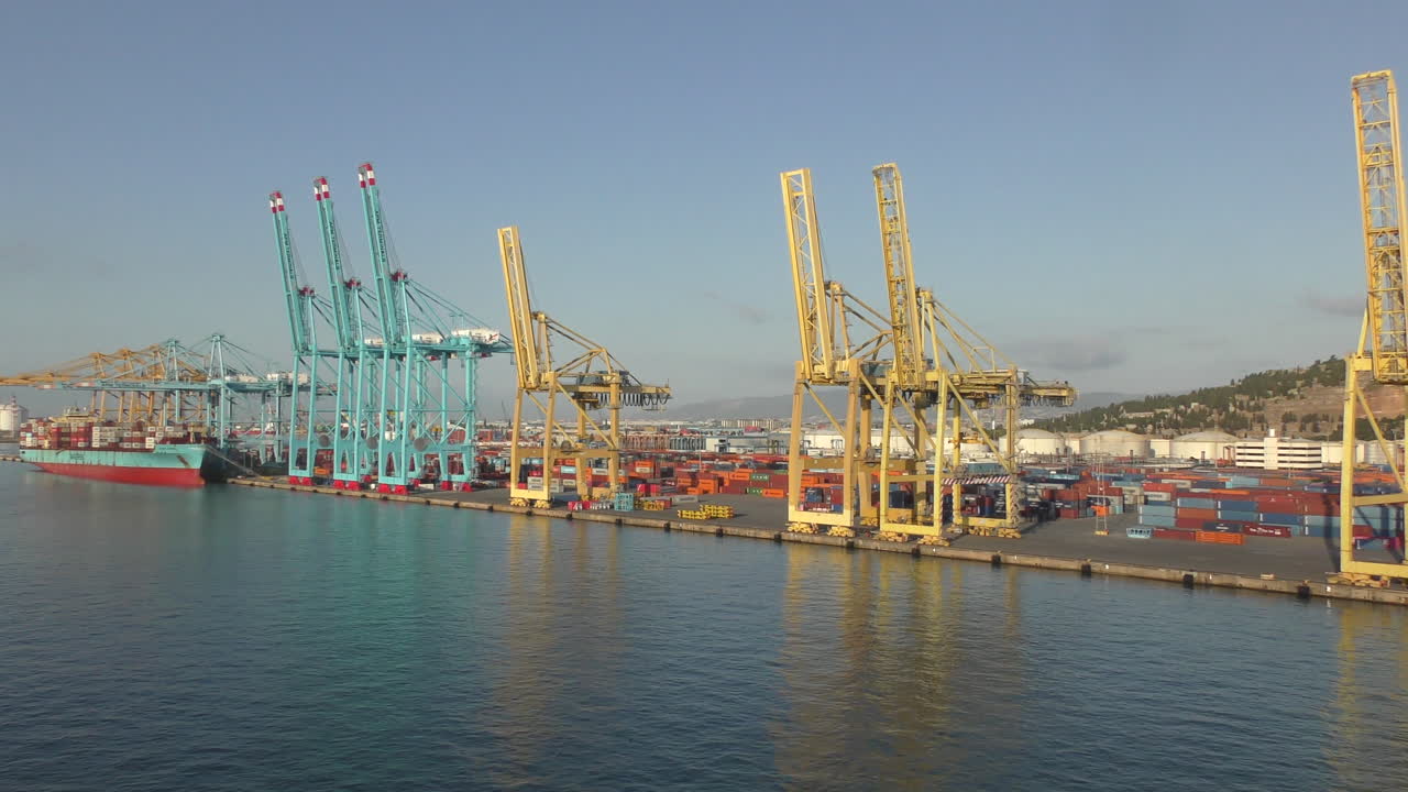 There are many containers and cranes in the port of Barcelona