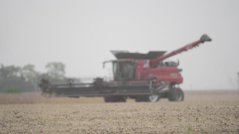 Combine-Harvester-on-a-Farm-Field-with-Lifted-Spinning-Header-on-a-Dusty-Day