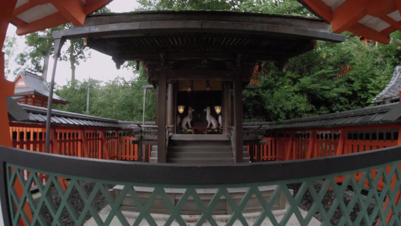 Camera moves toward a traditional Shinto shrine with orange gates in Kyoto, Japan