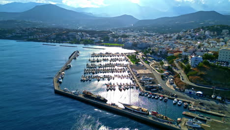 drone shot of agios nikolaos marina in greence on a sunny day with a mountain in the background