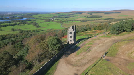 Stone-tower-building-alone-on-hillside-with-slow-flight-towards-and-past