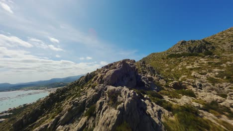 drone fpv volando bajo sobre colinas rocosas en mallorca