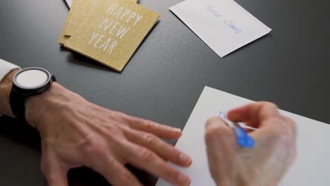 writing christmas wish letter to santa claus, envelopes on table