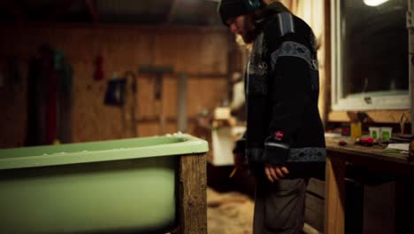 man marking wood with pencil, making diy hot tub in winter