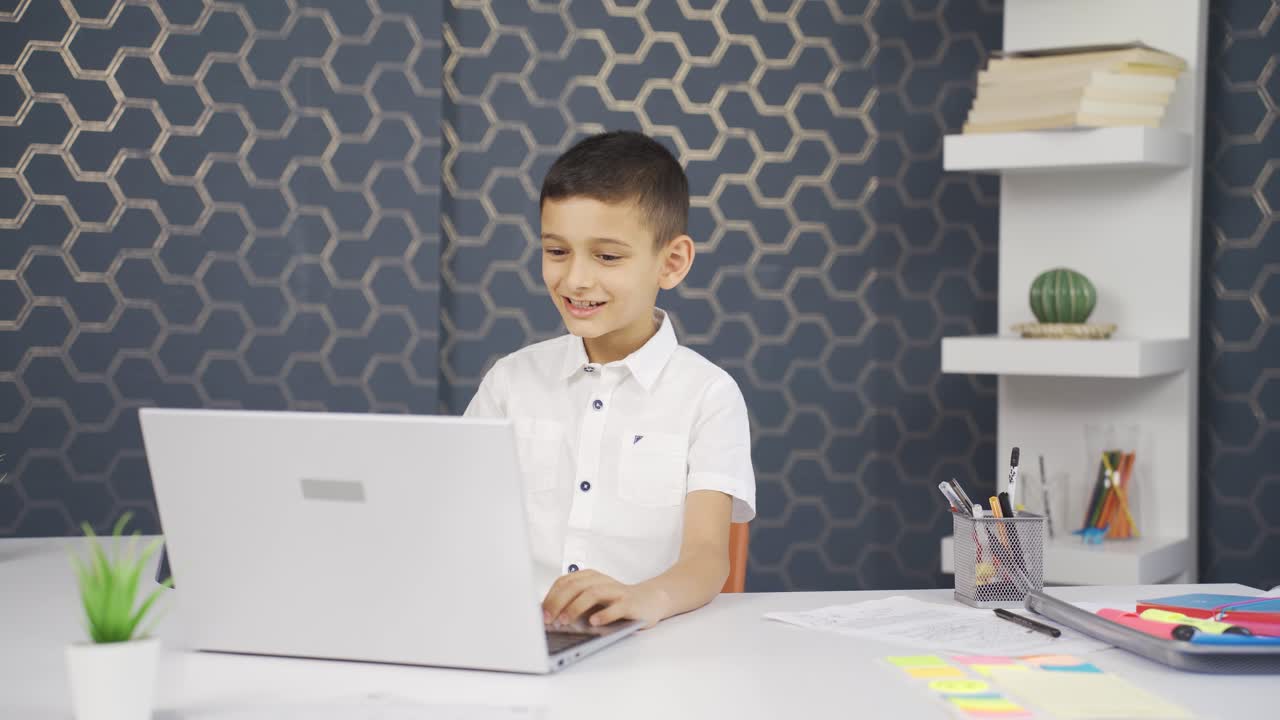 un chico estudiando en una computadora portátil hablando por facetime.