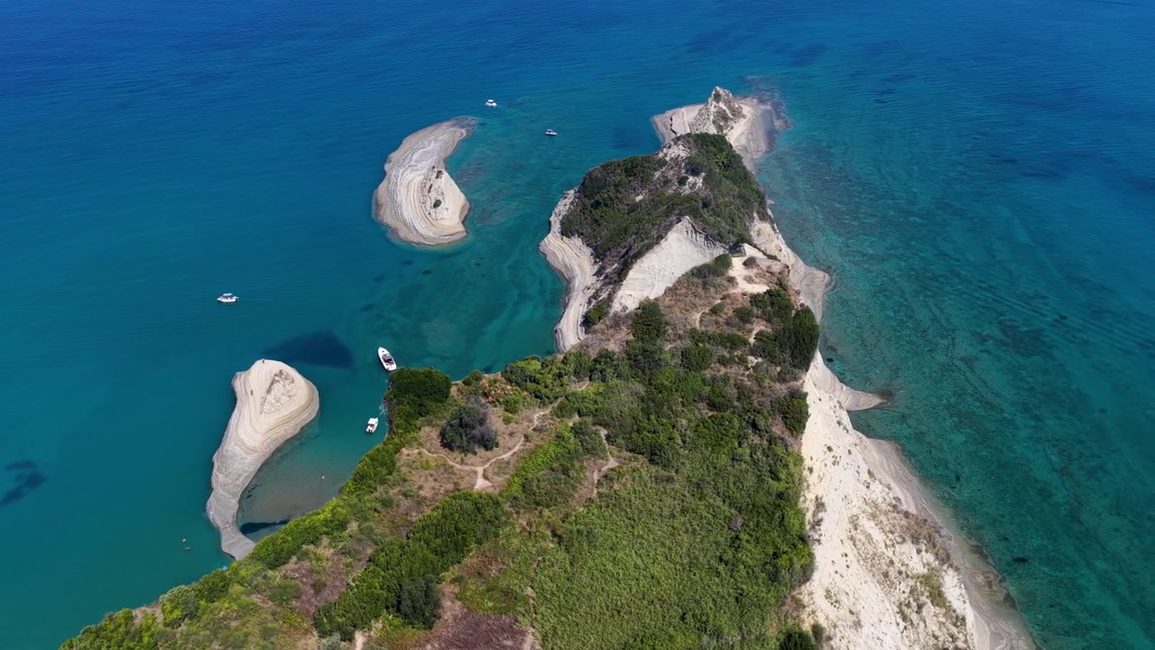 High angle aerial drone shot above the narrow white cliff peninsula of Cape Drastis Corfu Greece over turquoise ocean