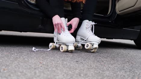 close up of female hands tie down shoestring on roller skates, slow motion