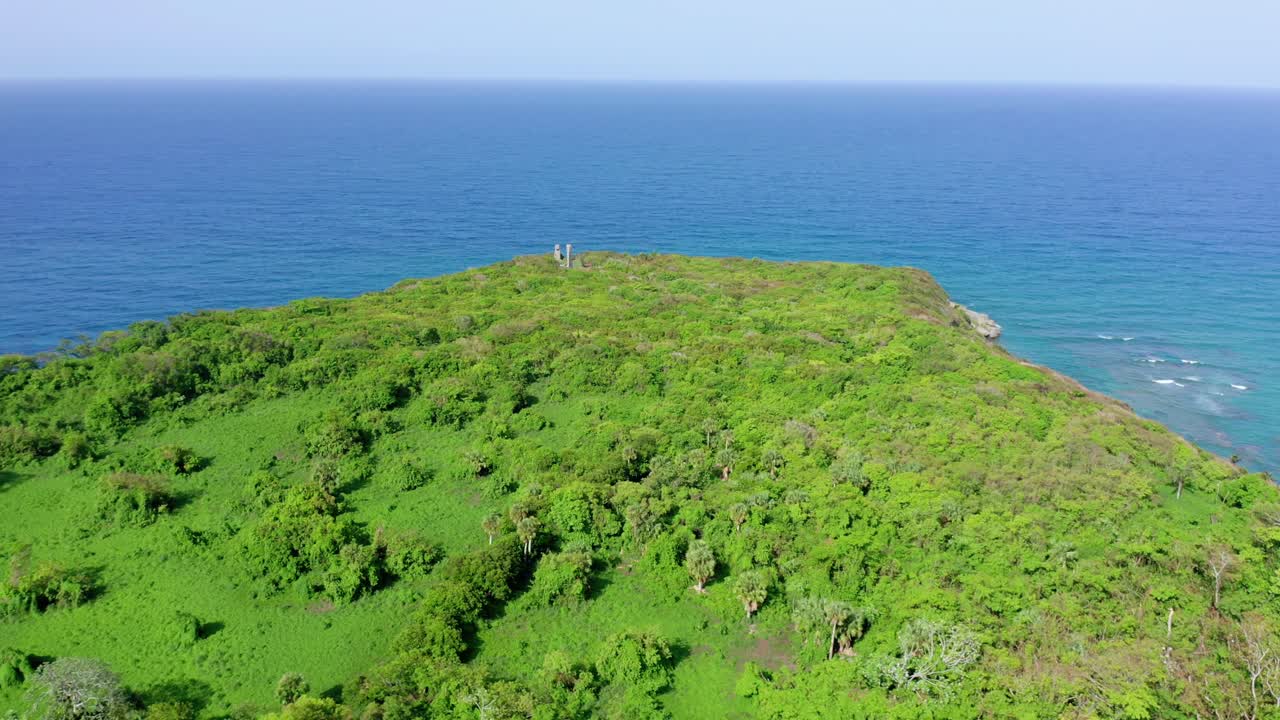 un espectacular acantilado cubierto de hierba verde frente al hermoso y tranquilo océano atlántico azul, tiro de drones en órbita circular, república dominicana