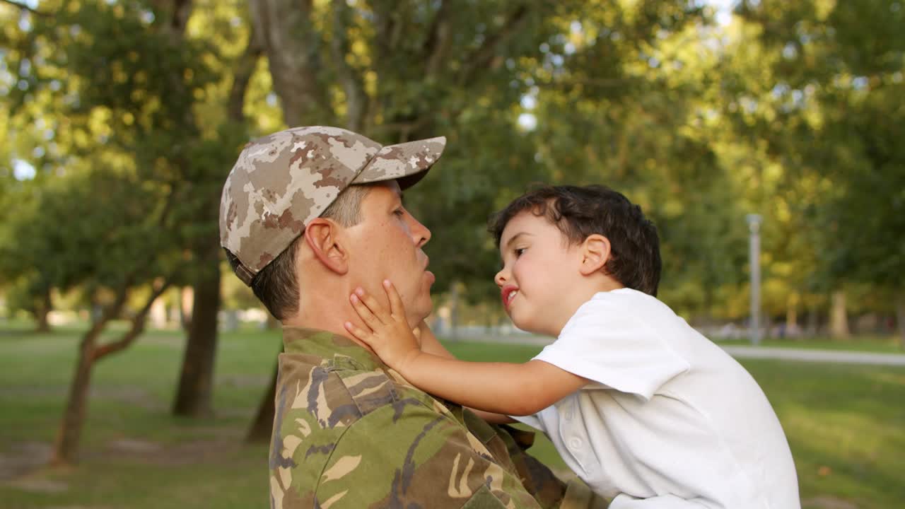papá militar fuerte sosteniendo a su pequeño hijo en brazos