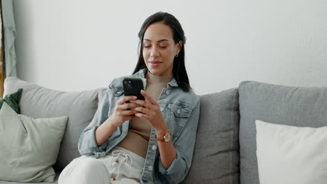 Woman,-relax-and-typing-on-smartphone-on-sofa