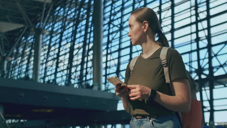 Mujer-Viajera-Con-Mochila-En-El-Aeropuerto-Mirando-El-Marcador-De-Salidas-Buscando-Su-Vuelo