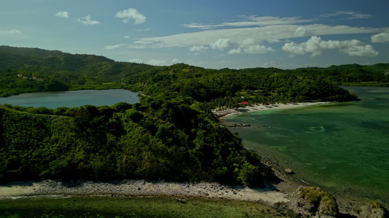 Colline verdi, spiagge di sabbia e acqua turchese nelle Filippine, ampia panoramica aerea.