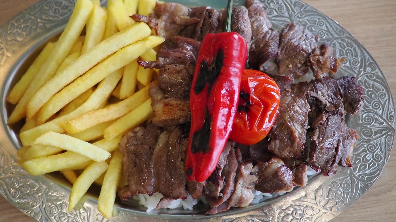 Doner Kebab tradizionale turco servito con patatine fritte e verdure grigliate