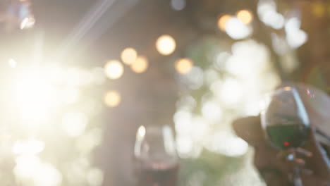 amigos bebiendo vino haciendo brindis celebrando una cena al atardecer sentados a la mesa charlando compartiendo estilo de vida personas relajándose al aire libre