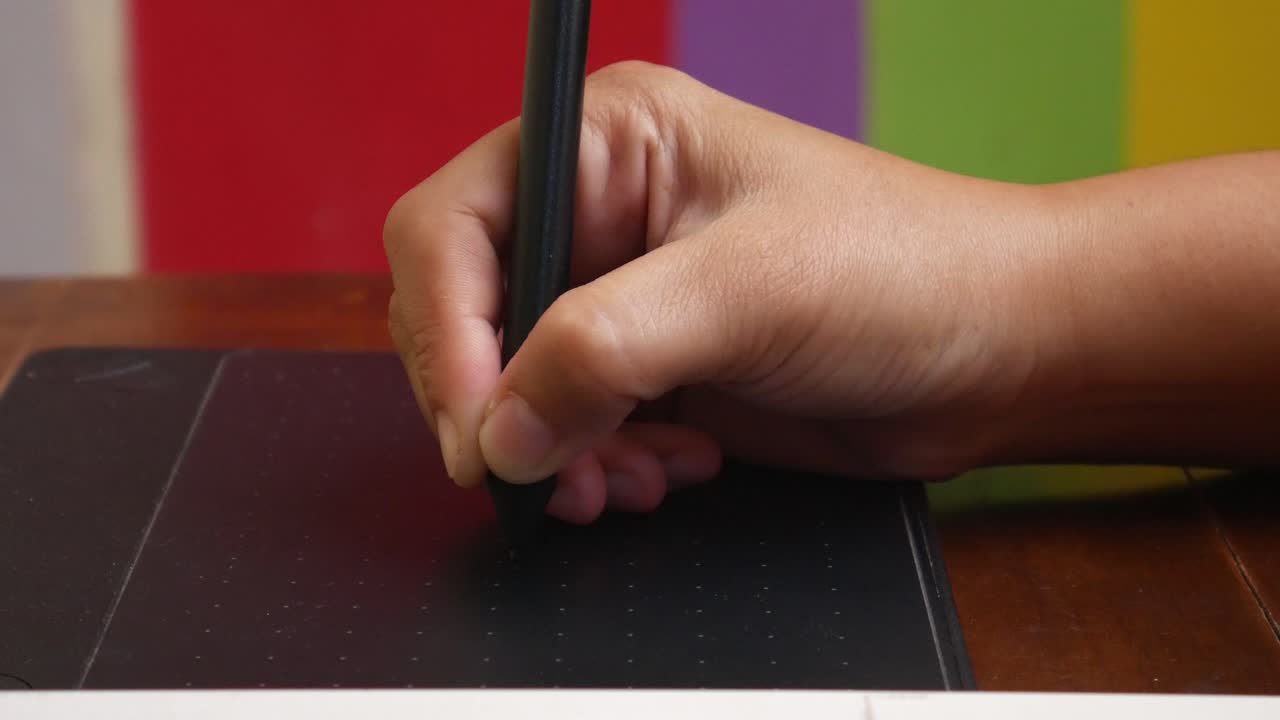 An illustrator's hand using a pen or stylus for drawing and designing