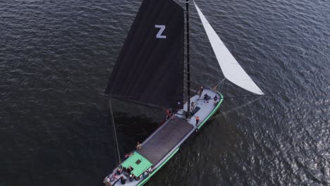 Top-down-of-classic-sailing-boat-Skutsje-cruising-on-lake-at-Friesland,-aerial