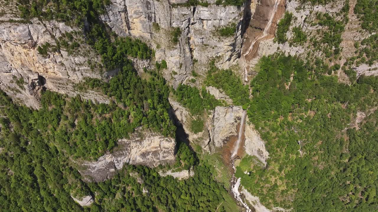 waterfall cuts through rocky cliffs and forest near walensee switzerland