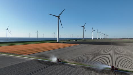 wind turbines, clean energy, blades spinning, amoung tulip fields. aerial drone view.
