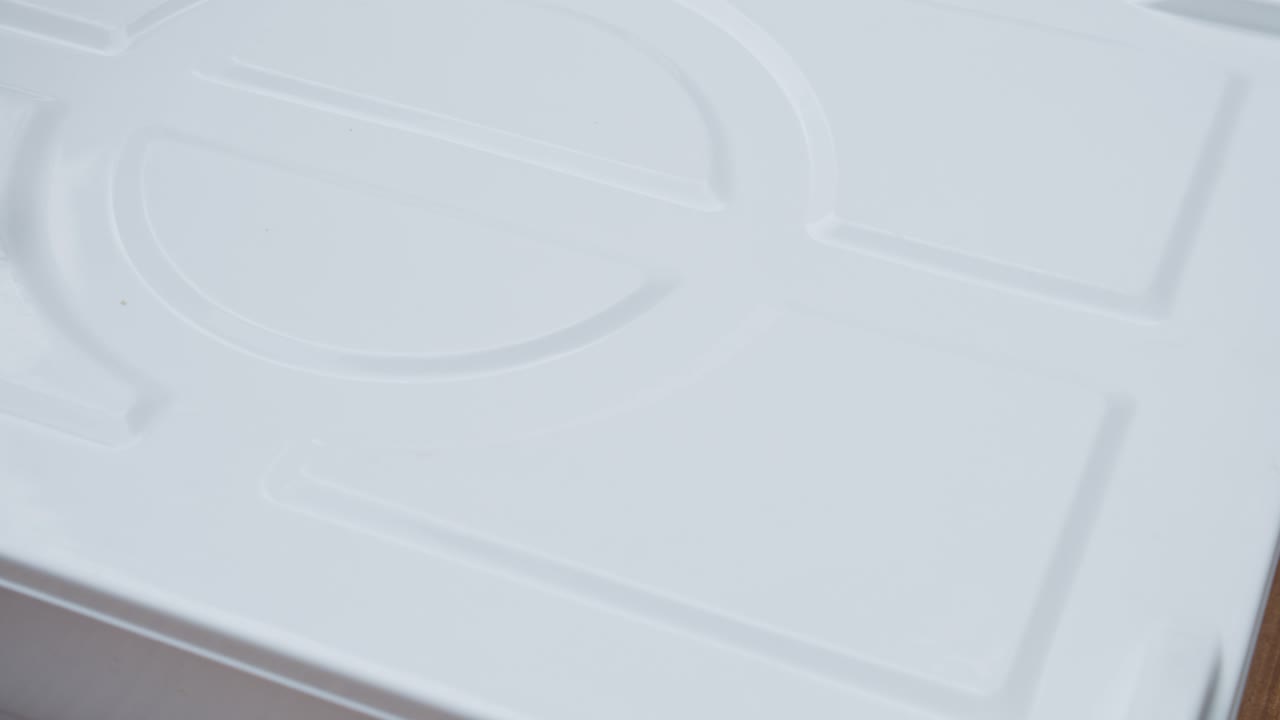 el chef coloca cuatro piezas de masa de pizza en una caja de almacenamiento para el proceso de elevación