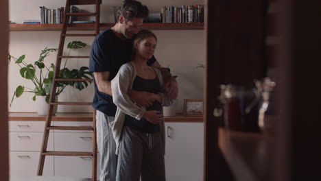 feliz pareja embarazada bailando juntos en casa marido abrazando a su esposa suavemente sosteniendo su vientre disfrutando de la danza íntima