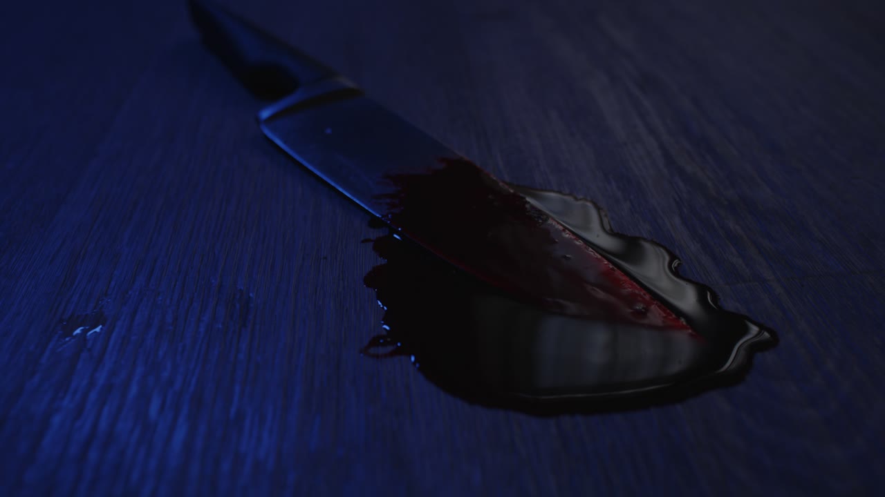 un cuchillo de cocina afilado cubierto de sangre yace en un charco de sangre en una horrible escena del crimen