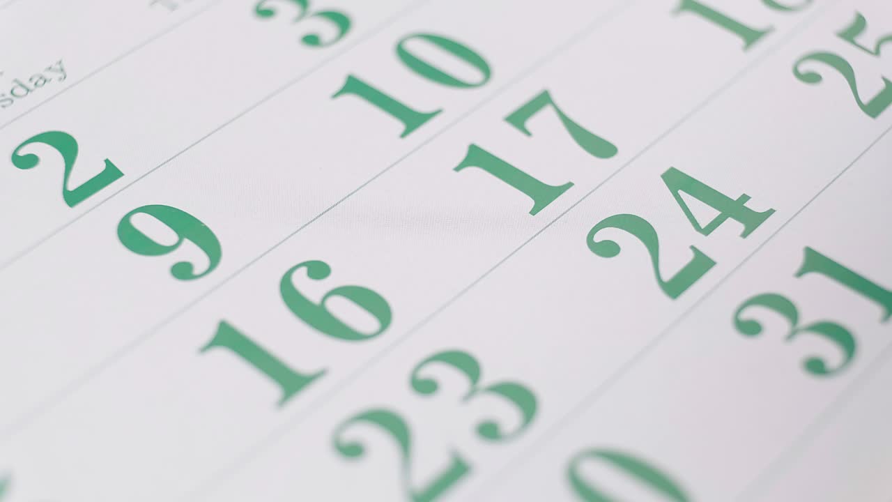 persona anotando fechas importantes en el calendario con un lápiz rojo.