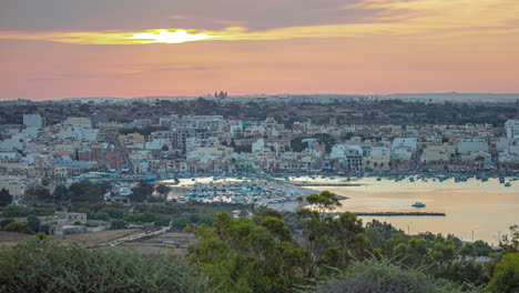 Una-Toma-De-Lapso-De-Tiempo-Del-Sol-Desapareciendo-En-Las-Nubes-Vista-En-Un-Puerto-En-Una-Ciudad