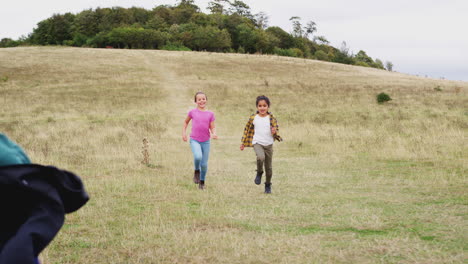 Vorderansicht-Einer-Gruppe-Von-Kindern-Auf-Einem-Outdoor-Campingausflug,-Der-Bergab-Läuft