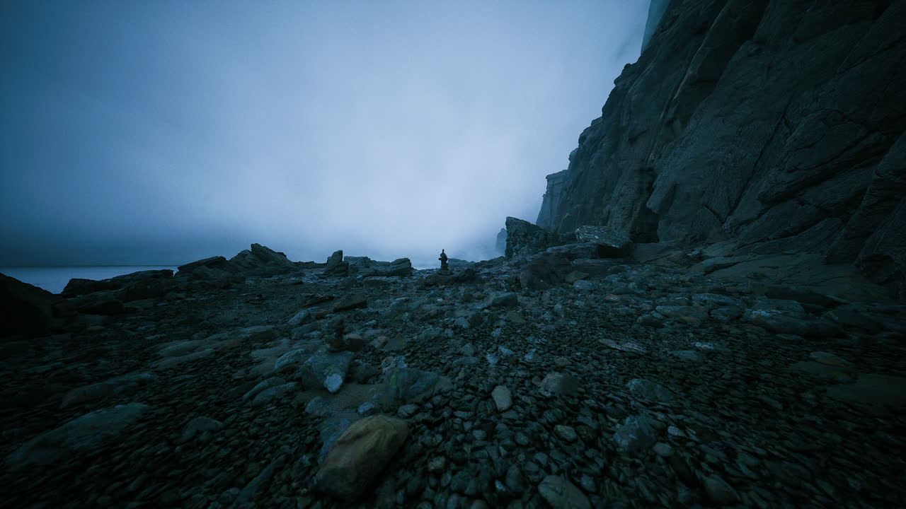 Exploring rocky coastline under grey skies at dusk with waves crashing nearby