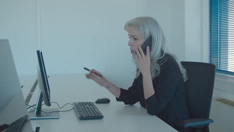 mujer de negocios de cabello blanco enfocada usando computadora