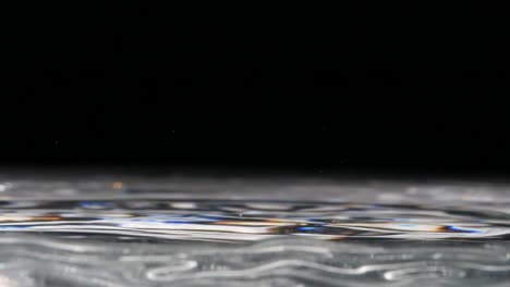 drops of water falling in a clear water pool -close up