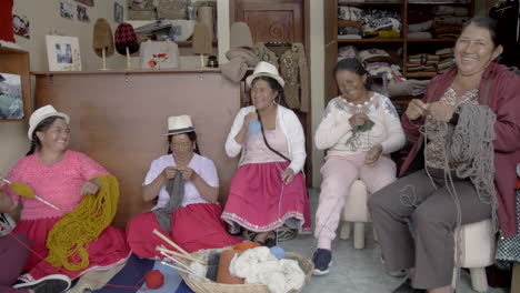 group of indigenous women knitting and smiling
