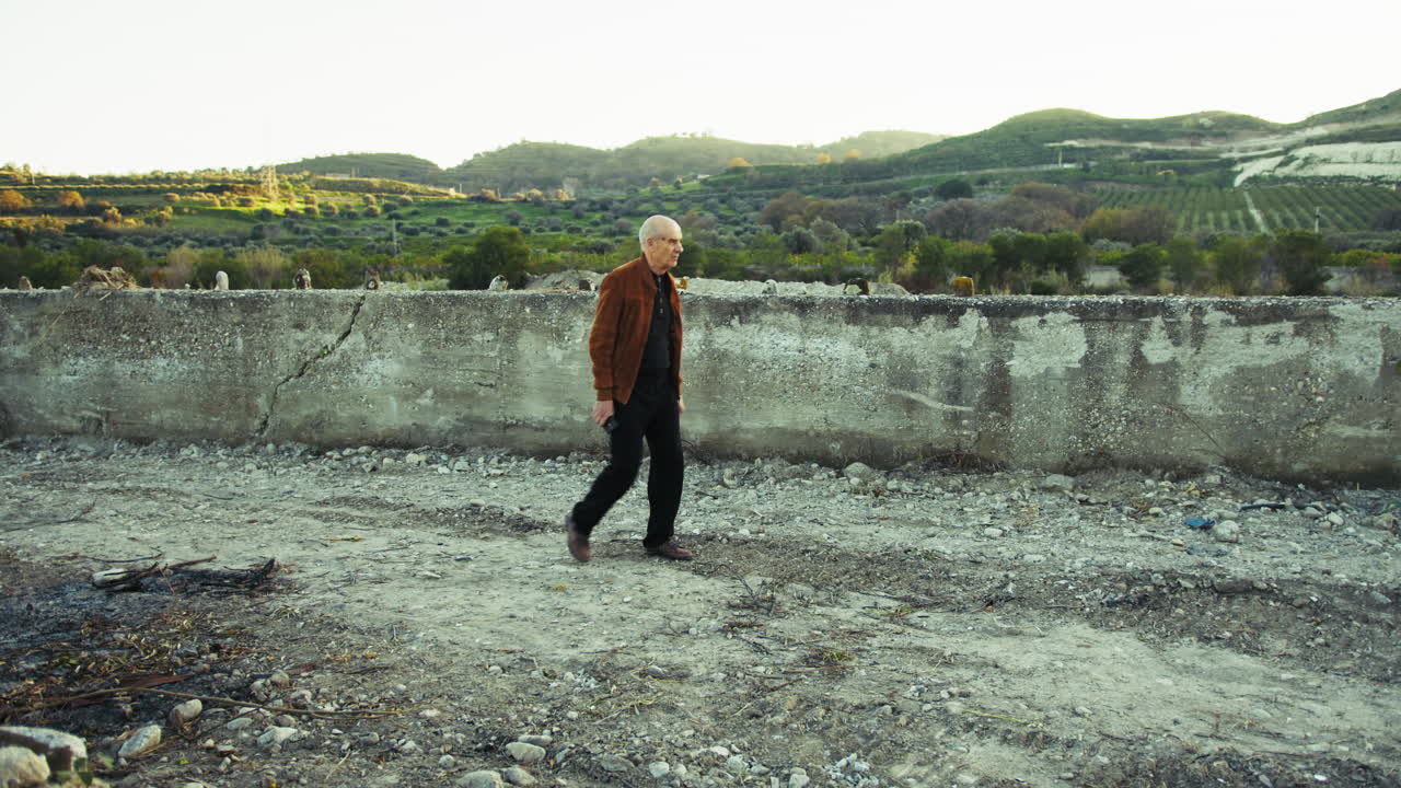 Elderly Man Walking Among Natural Ruins