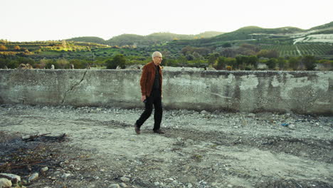 elderly man walking among natural ruins