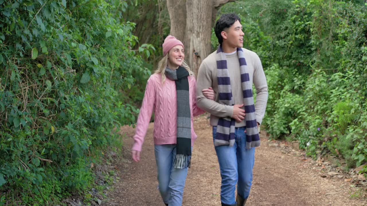 Mencapai puncak, pasangan menuruni hutan mengenakan syal bergaris, bergandengan tangan dan mengagumi pohon cedar