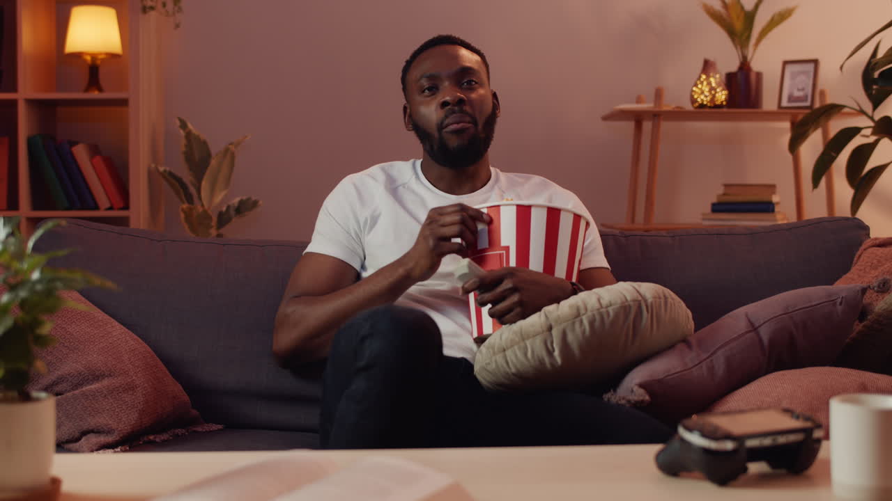 hombre viendo la tv con palomitas de maíz