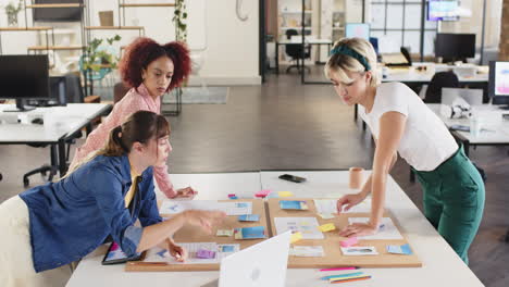 collaborating on project, three women brainstorming with sticky notes in office