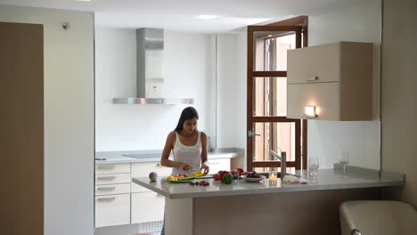 mujer preparando una ensalada de frutas en una cocina moderna
