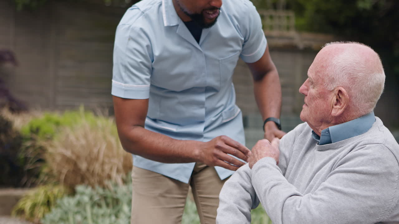 Caregiver assisting elderly man in the garden