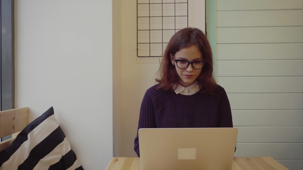 mujer trabajando en una computadora portátil en una cafetería