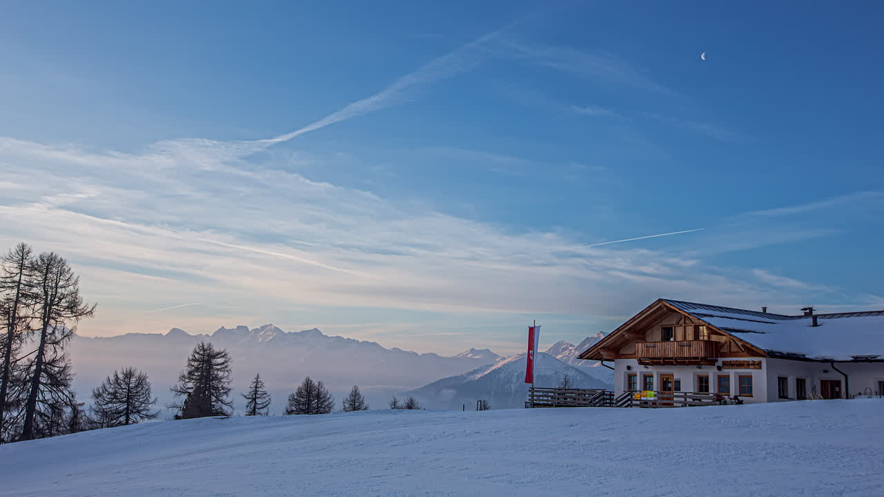 tiro de lapso de tiempo de hermoso amanecer en la cima de las montañas nevadas en la mañana - cabaña de madera con ondeando la bandera austriaca - alpes, austria